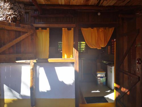 an open door to a room with yellow curtains at CHEZ ALEX in Nosy Be