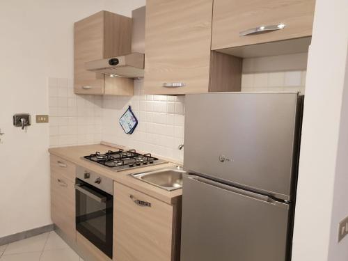 La cuisine est équipée d'un réfrigérateur en acier inoxydable et d'un évier. dans l'établissement Terre Apartment, à Corniglia