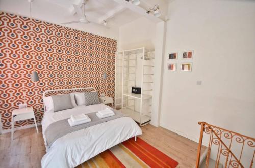 a bedroom with a bed and a red and white patterned wall at Eight Point Living 34B in Birgu