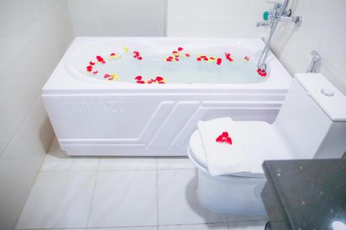 y baño con aseo y bañera con flores. en Long Anh Hotel en Thanh Hóa
