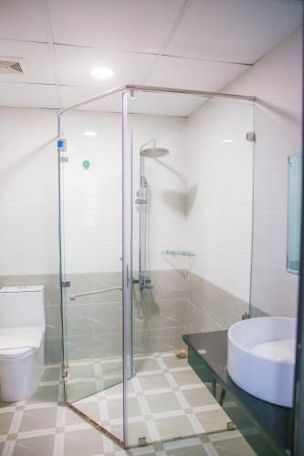 a bathroom with a glass shower and a toilet at Long Anh Hotel in Thanh Hóa
