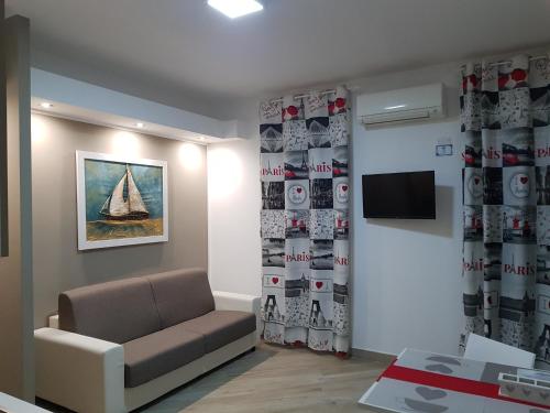 a living room with a couch and a tv in a room at Residenza Lumière in Termoli