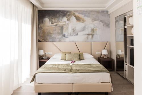 a bedroom with a large bed with a painting on the wall at Villa Cavalletti Camere in Grottaferrata
