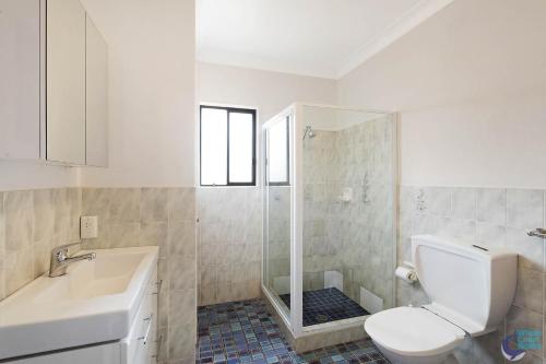 La salle de bains est pourvue de toilettes, d'un lavabo et d'une douche. dans l'établissement Pacific Pines Unit 6, à Narooma