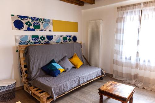 um quarto com uma cama com almofadas coloridas em La Casa di Bassano em Bassano del Grappa