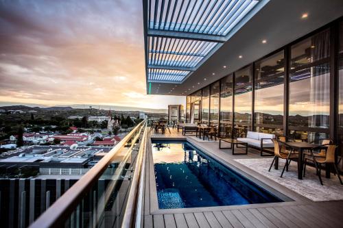 a building with a swimming pool on a balcony at Avani Windhoek Hotel & Casino in Windhoek