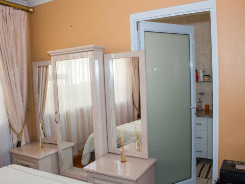 a bedroom with two mirrors and a bed at Onyx on Sycamore in Cape Town