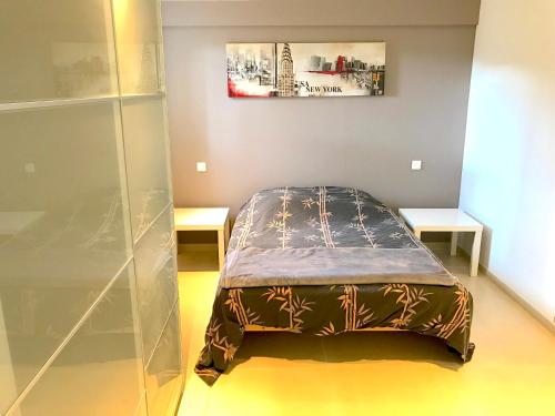 a bed in a room with two tables at T2 Moderne avec jardin in Rayol-Canadel-sur-Mer