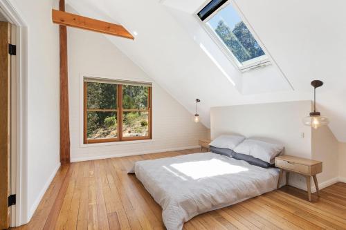 a white bedroom with a bed and a window at 275 Ridge Road Central Tilba in Central Tilba