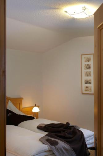 a bedroom with a bed and a light on the ceiling at Landhaus Alpensonne in Schattwald