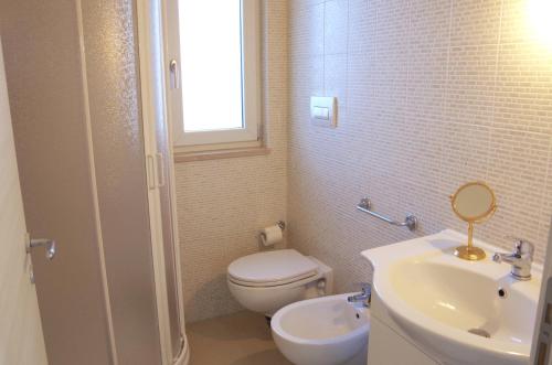 La salle de bains blanche est pourvue de toilettes et d'un lavabo. dans l'établissement Villa Ani, à Villanova di Ostuni