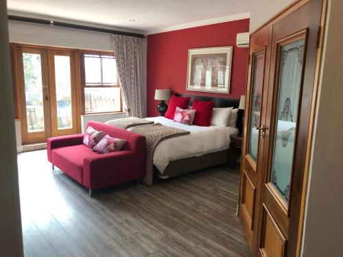 a bedroom with a bed and a red wall at 314 on Clark Guest House in Pretoria