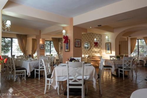 a dining room with white tables and chairs at Pensiunea Diamant in Ghimbav