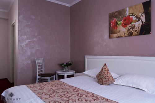 a bedroom with a bed and a painting on the wall at Pensiunea Diamant in Ghimbav