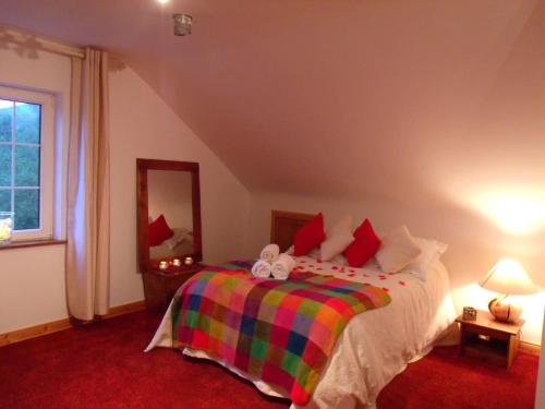 1 dormitorio con 1 cama con una manta colorida en tranquil apartment near Kenmare en Lomanagh