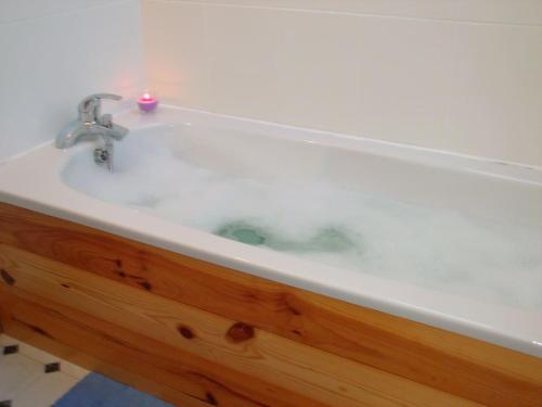 a white bath tub with a candle in it at tranquil apartment near Kenmare in Lomanagh