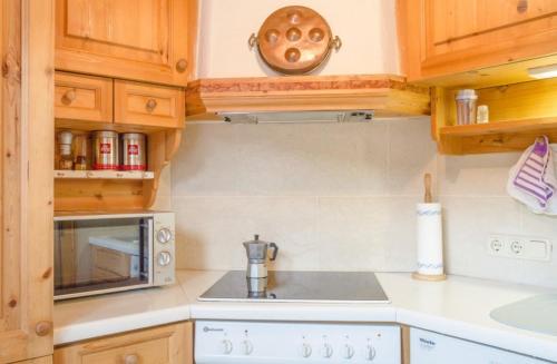 a kitchen with wooden cabinets and a counter top at Ferienwohnung Weinfurter Luise in Ellmau