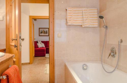 a bathroom with a bath tub with a shower at Ferienwohnung Weinfurter Luise in Ellmau
