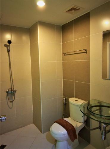 a bathroom with a toilet and a glass shower at Retreat Resort Pattaya in Nong Prue