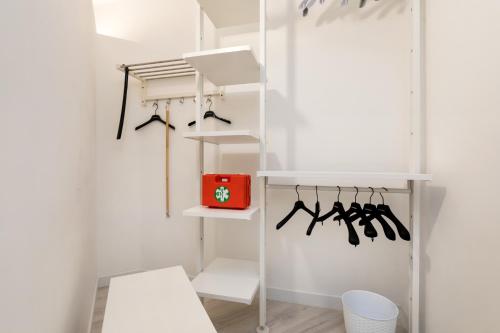 un placard blanc avec des étagères blanches et une boîte rouge dans l'établissement Venice Heaven Apartments Biennale, the Elegant Residence, à Venise