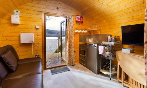a kitchen and living room with a view of the water at Hill Of Oaks in Windermere