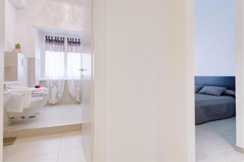 a white bathroom with a bed and a sink at Elements Guest House in Rome