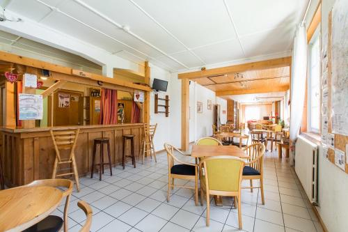 a restaurant with tables and chairs and a bar at Village Vacances Le Salvagny in Sixt