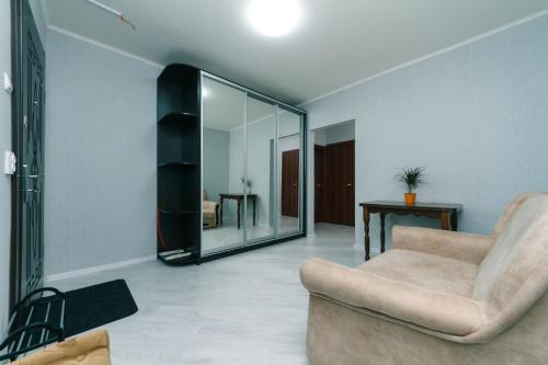 - un salon avec une chaise et un miroir dans l'établissement Видовая квартира Yaroslavichi-2, à Vychhorod