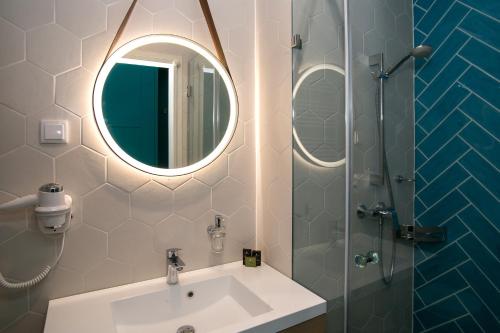 a bathroom with a sink and a shower with a mirror at T62 Hotel in Budapest