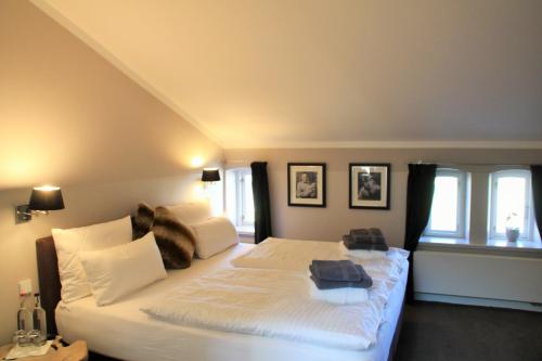 a bedroom with two beds and two windows at Herrenhaus Gut Neuruppersdorf in Timmendorfer Strand