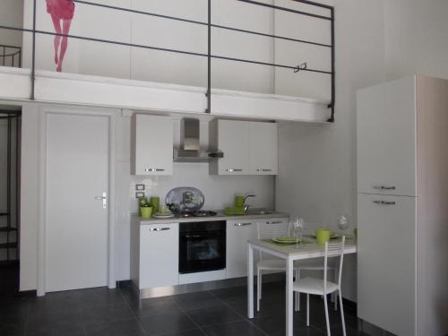 a kitchen with white cabinets and a table with chairs at Loft Regio Parco in Turin