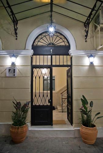 a front door of a building with two potted plants at Four Streets Athens - Luxury Suites Apartments in Athens in Athens