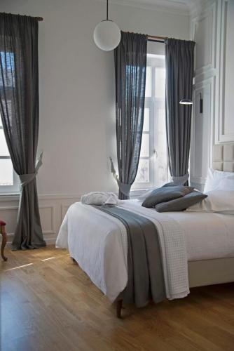 a bedroom with a large bed with gray curtains at Four Streets Athens - Luxury Suites Apartments in Athens in Athens