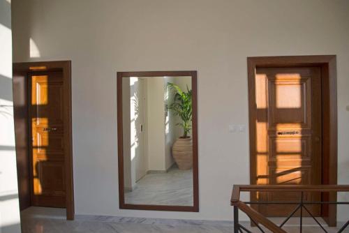 a mirror on a wall in a room with a plant at Four Streets Athens - Luxury Suites Apartments in Athens in Athens