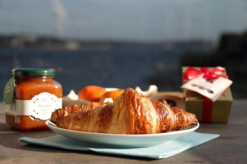 a plate of food with a croissant and a jar of sauce at Hotel Modo in Pula