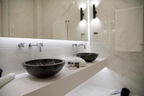 a bathroom with two black bowls on a counter at Four Streets Athens - Luxury Suites Apartments in Athens in Athens
