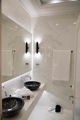 a white bathroom with two sinks and towels at Four Streets Athens - Luxury Suites Apartments in Athens in Athens
