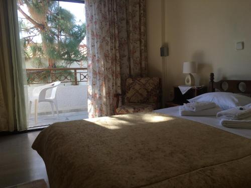 a bedroom with a bed and a window with a patio at Chris Studios & Apartments in Lechaio