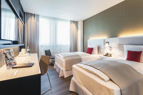 a hotel room with two beds and two lamps at Riu Plaza Berlin in Berlin