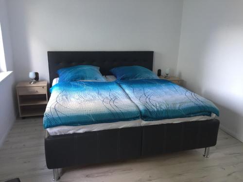 - un lit avec une couette bleue et 2 oreillers dans l'établissement Ferienhaus auf Usedom, à Zinnowitz