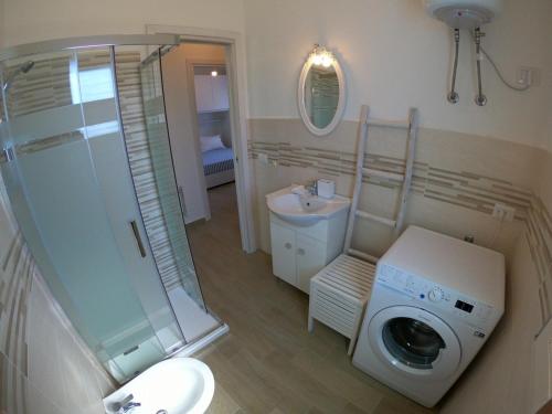 a bathroom with a washing machine and a sink at Villino Blu Mare in San Teodoro