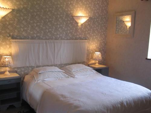 a bedroom with a large white bed with two lamps at RAND'HÔTES in Les Genettes
