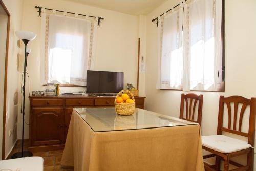 una cocina con una mesa con una cesta de fruta. en Abuela Pastora en El Torno