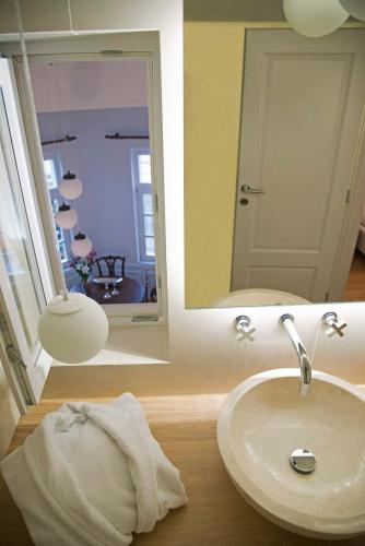 a bathroom with a sink and a mirror at Four Streets Athens - Luxury Suites Apartments in Athens in Athens