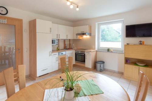 eine Küche mit einem Tisch und einem Esszimmer in der Unterkunft Appartementhaus Monika in Flattach