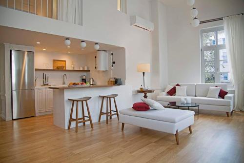 a kitchen and living room with a couch and a table at Four Streets Athens - Luxury Suites Apartments in Athens in Athens