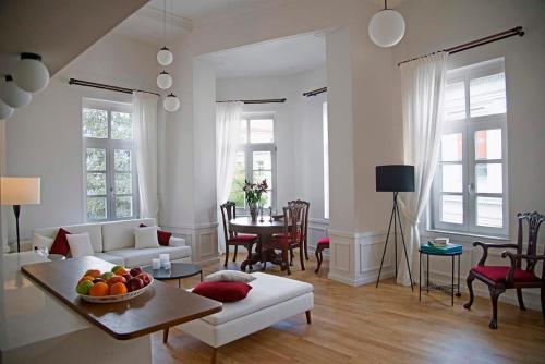 a living room with a white couch and a table at Four Streets Athens - Luxury Suites Apartments in Athens in Athens