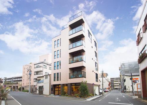 a tall white building on the side of a street at SOLA HOTEL in Tokyo