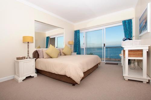 a bedroom with a large bed and a large window at Port Main Royal Ocean's Edge in St Francis Bay