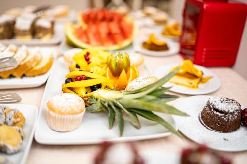 a table topped with plates of desserts and pastries at New Era Hotel Old Town Bucharest- parking with fee nearby - NOT at the hotel ! in Bucharest